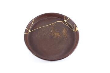 Kintsugi, antique brown plate restored with real gold