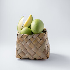 natural and raw or green mangos or aam in a basket with mango tree leaves on a white background for...