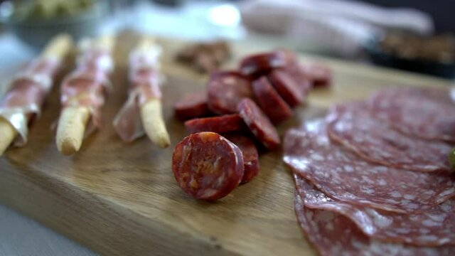 Macro close up pan dolly footage over a charcuterie board. Cold cured meats include chorizo, salami and prosciutto. Artisan food footage concept filmed with natural dalight.