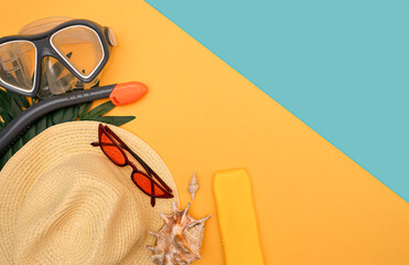 Beach holiday set, swimming mask, hat, sun cream, shell on a yellow background, next to the blue sea. The concept of relaxation on the beach, sea, pool. copy space for text. Flat lay, top view