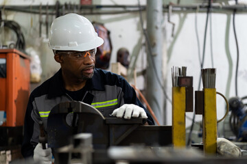 African American male engineer worker maintenance machine in the factory. Black male worker working...