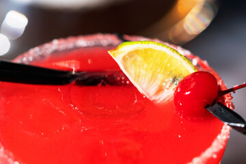 Raspberry alcoholic cocktail in a glass with foam sprinkled with freeze-dried raspberries in the hookah smoke on the table.
