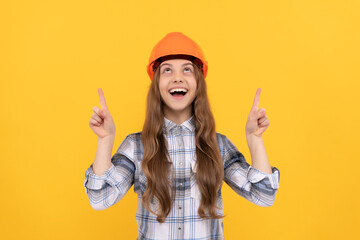 happy teen girl in helmet and checkered shirt pointing finger up, demonstrate