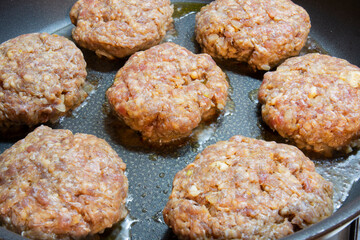  Raw. homemade burger meatballs are cooked in a cast iron pan. Selective Focus Burger meatballs.