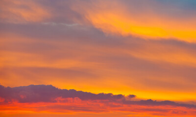 Fototapeta premium Beautiful orange clouds in the summer sunset sky (background)