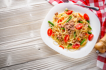 delicious traditional Italian pasta with tuna on a white rustic wooden background