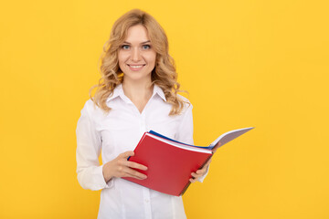 happy blonde businesswoman woman in white shirt making notes in notepad or notebook, executive