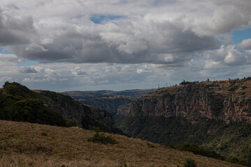 Fototapeta premium Steep Rocky Cliffs Leading Down into a Tree Lined Gorge