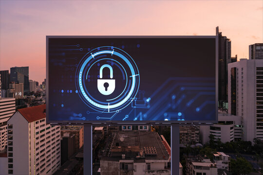 Padlock icon hologram on road billboard over panorama city view of Bangkok at night to protect business, Southeast Asia. The concept of information security shields.