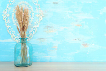 wheat crops over table and blue wooden background. Symbols of jewish holiday - Shavuot