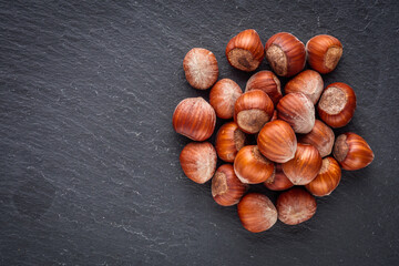 fresh natural hazelnuts on a dark stone background