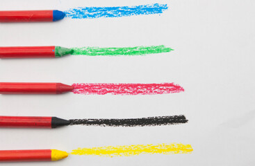 Kid's drawn rainbow and colorful crayons on white background