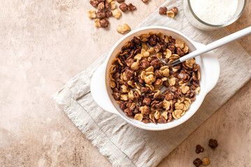 Tasty and healthy breakfast. Chocolate and vanilla cornflakes with milk in a white bowl top view. Breakfast cereals.