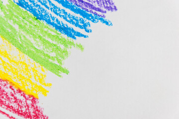 Kid's drawn rainbow and colorful crayons on white background