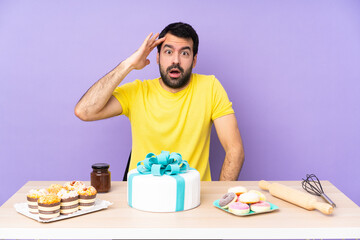 Man in a table with a big cake has just realized something and has intending the solution