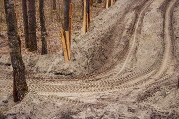 Track and tread marks of a country sandy forest road in summer. Off-road background. - obrazy, fototapety, plakaty