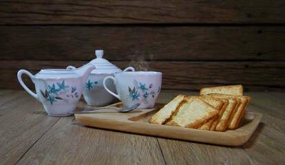 Crackers in wooden trays and tea sets on old wood floors and walls