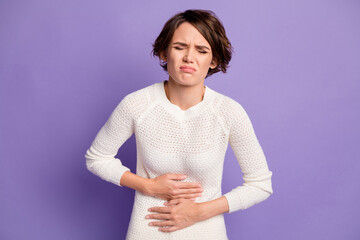 Portrait of attractive lady suffering stomach ache hands on belly closed eyes sullen isolated on...