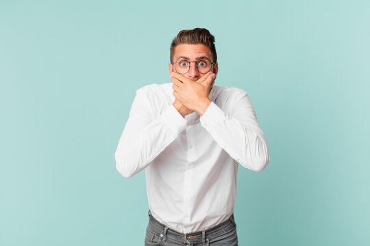 young handsome man covering mouth with hands with a shocked