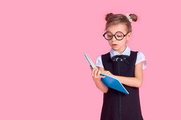 Cute little girl with glasses and books on pink background, spac