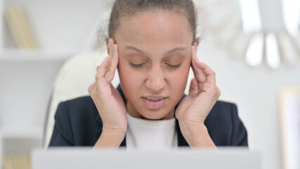 African Businesswoman with Laptop having Headache 