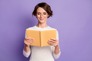 Photo portrait of smart female student reading book preparing for exam isolated on vivid violet color background