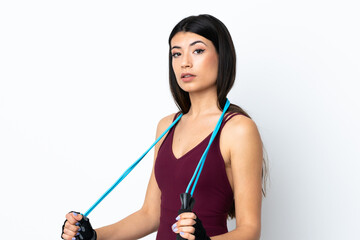 Young sport woman over isolated white background with jumping rope