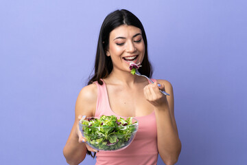 Young woman with salad over isolated purple background