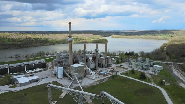 Aerial birds eye view shot of a big industrial factory near the riverside. High quality 4k footage
