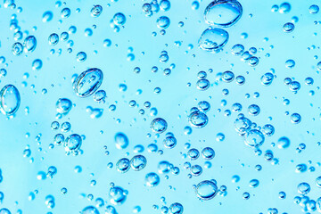 Close up macro Aloe vera gel cosmetic texture blue background with bubbles. Lemongrass gel skincare product. antibacterial liquid with aloe vera, moisturizing. Safe and environmental friendly.