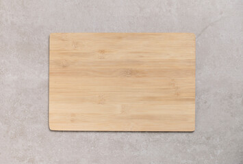 Empty wooden cutting board on old gray concrete background. Top view with copy space for your text.