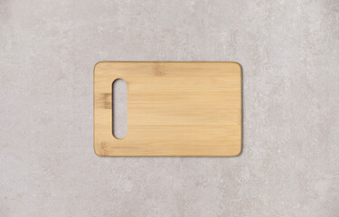 Empty wooden cutting board on old gray concrete background. Top view with copy space for your text.