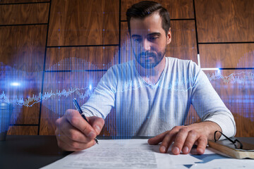Good looking man working on investment project. Multiexposure. Forex graph Hologram.