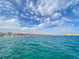 Mobile photography of the sea at Naama Bay, Red Sea and motor yachts, Sharm el Sheikh, Egypt. Resort town and beach. Blue sky with clouds. Background texture with summer concept.
