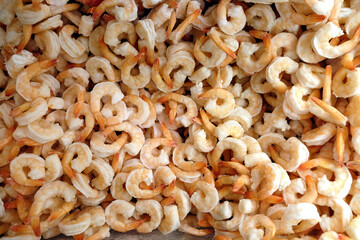 Still-life with lot of frozen peeled pink-white  shrimp as background in the freezer in department store shop top view close-up