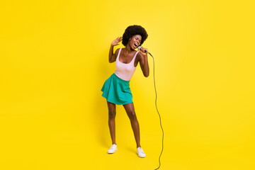 Full size photo of pretty afro american charming woman wear pink singlet good singer karaoke isolated on yellow color background - obrazy, fototapety, plakaty