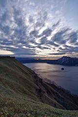 Fototapeta na wymiar 薄い雲の広がる夜明けの湖。日本の北海道の摩周湖。