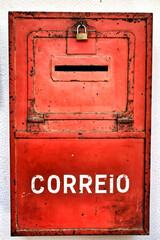 Colorful metallic mail box in red color on wall with old paint