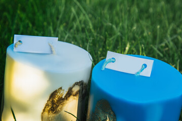 homemade multi-colored candles with concrete on a background of green grass. handmade decor...
