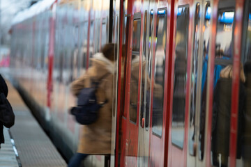 Menschen mit Masken am Bahngleis im Hauptbahnhof Köln bei der Einfahrt des Zuges - obrazy, fototapety, plakaty