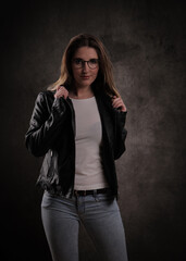 Close-up of a young attractive woman against dark grey background - studio photography