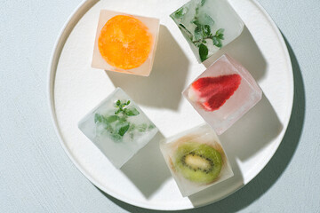 Frozen ice cubes with fruits, berries, herbs on a white background. Home preservation of food during the quarantine period. Freezing is a safe method. Home food concept