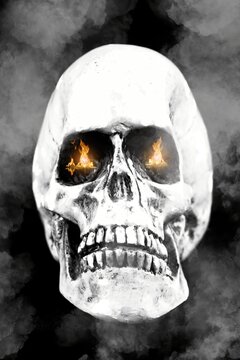 Old human white skull including teeth with flames in eye sockets. Halloween horror concept.