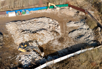 Recycling concrete and construction waste from demolition. Excavator at landfill of the disposal....