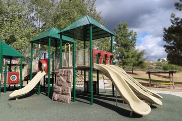 Playground Slide with 4 Chutes and A Climbing Wall Trees in Background