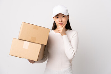 Young delivery Chinese woman over isolated white background laughing