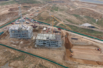 Tower cranes in action at construction site. Crane during formworks. Soil Compactor leveling ground...