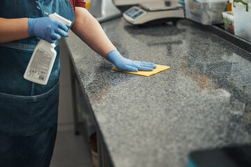 Responsible kitchen staff cleaning and desinfecting work surfaces - obrazy, fototapety, plakaty