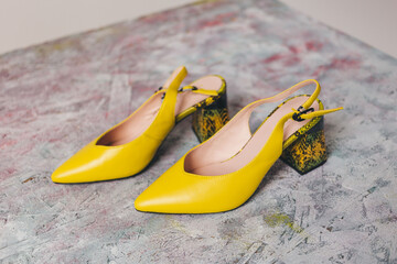 Yellow low heels with leopard pattern on light backgorund.