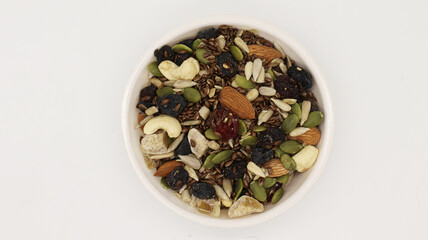 Healthy trail mix snack made of nuts (walnut, almond, peanut) and dried fruits (raisin, sultana) on iron scoop (Selective Focus, Focus on the front of the almond)